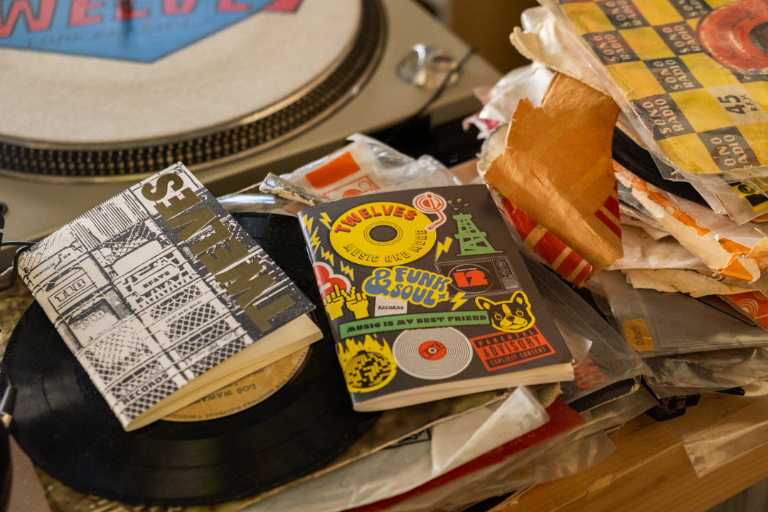Two special edition TRAVELER'S notebook refill (Passport Size) sitting next to a stack of 7-inch vinyls.