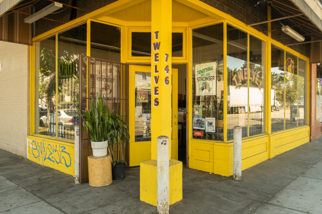 The bright yellow pillar and store exterior of TWELVES RECORD.
