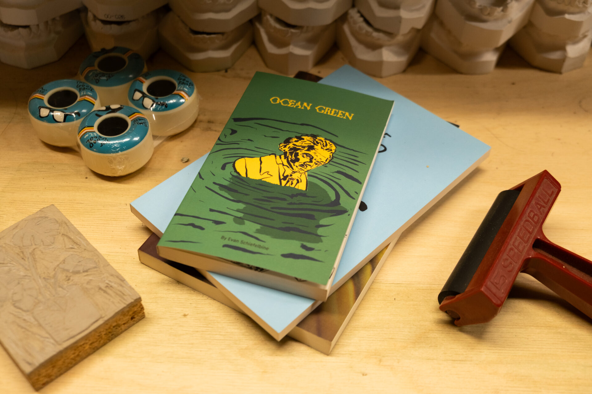 Tony Bach's past graphic design work on a wooden table in his creative studio behind TWELVES RECORD.