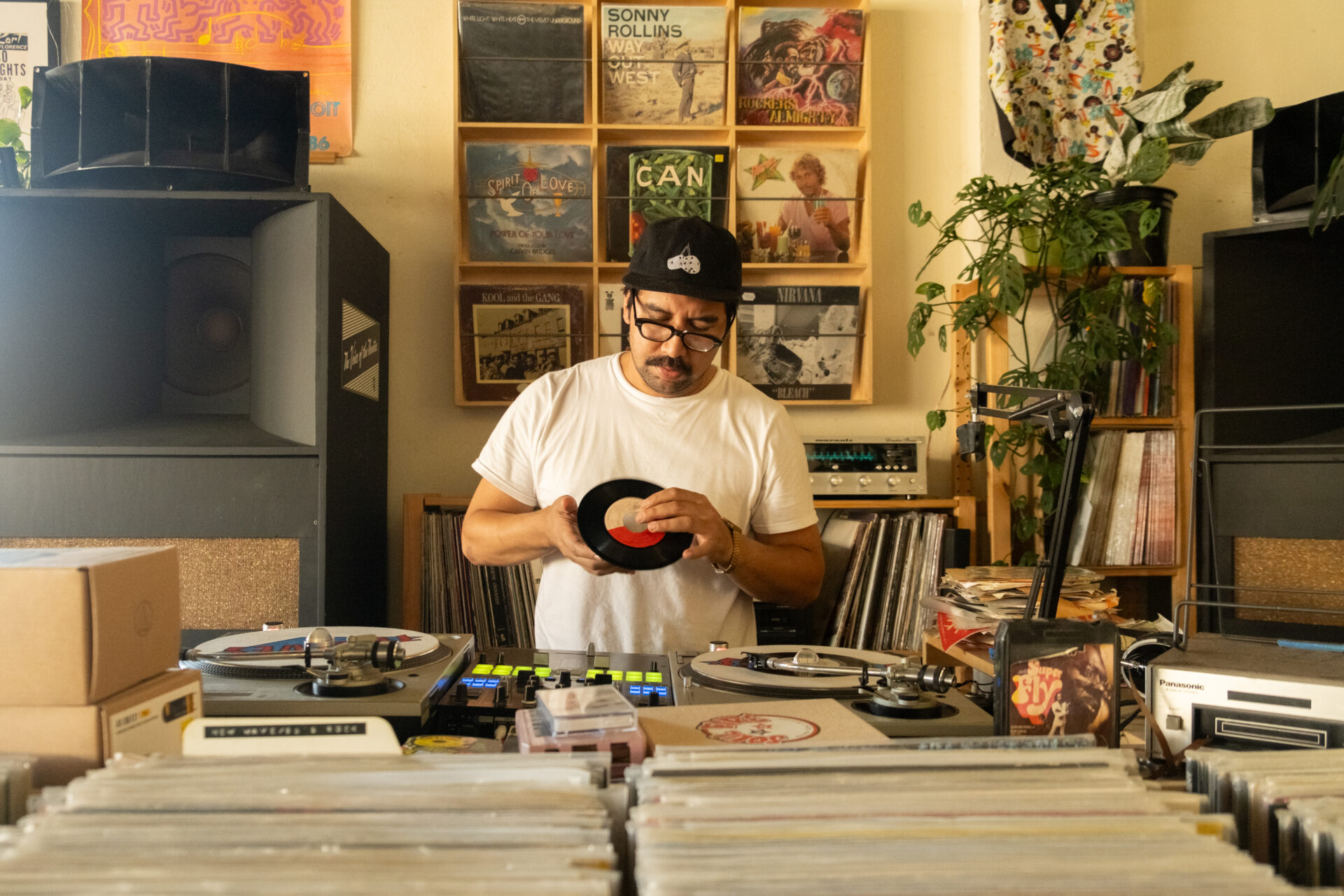 Shop owner Hector behind a DJ booth at TWELVES RECORD, where Hector is DJing.