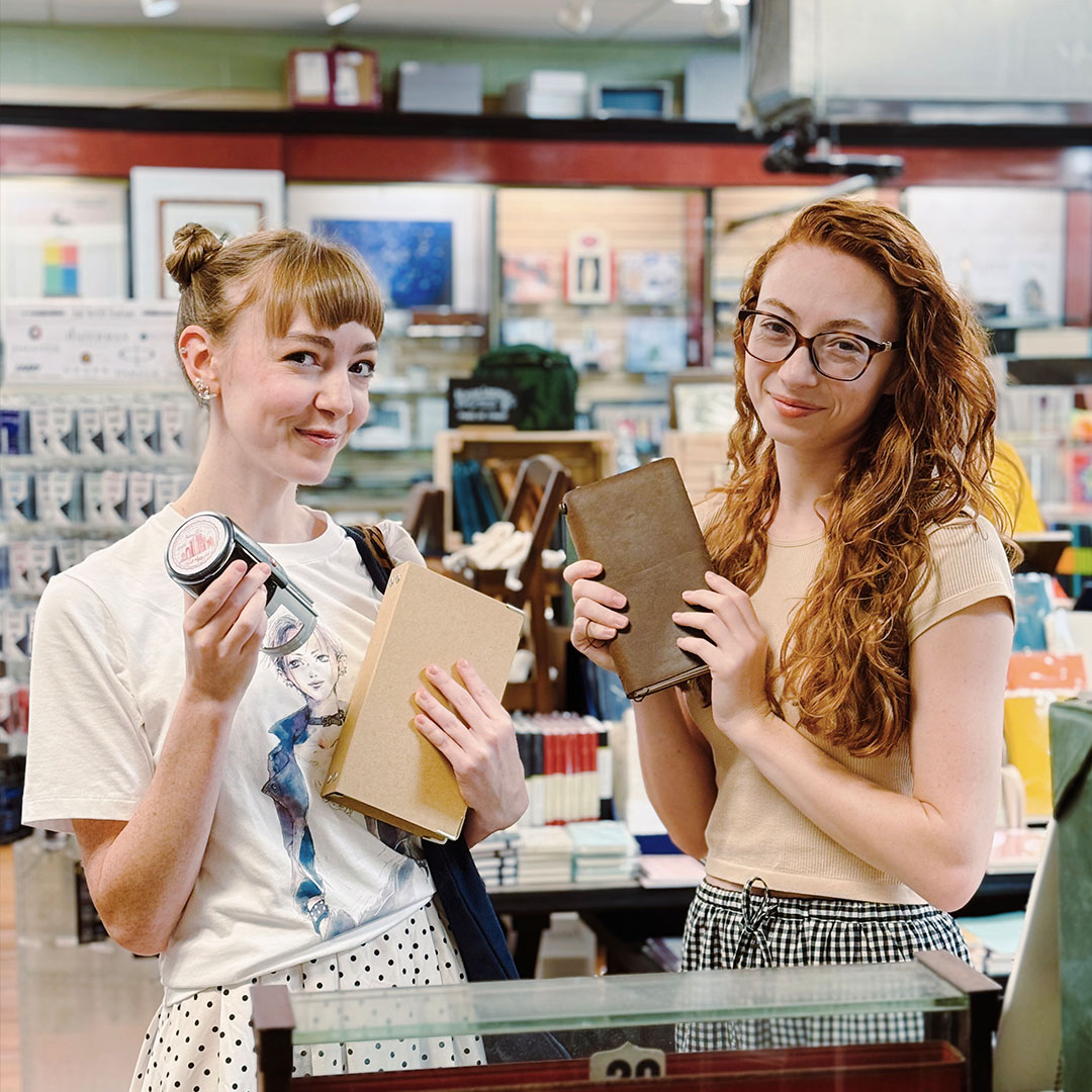 Customers holding up their stationery purchases inside Dromgoole's.