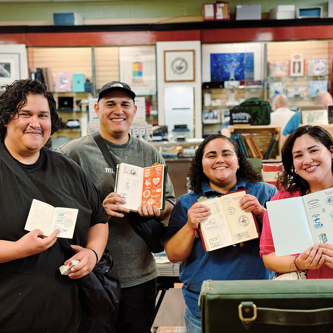 TRAVELER'S notebook fans holding up their TRAVELER'S notebooks.
