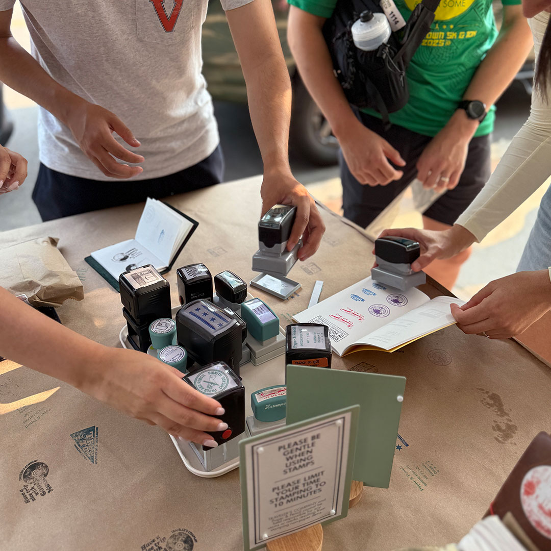 TRAVELER'S notebook fans utilizing the stamps at a table outside the Paper and Pencil store.