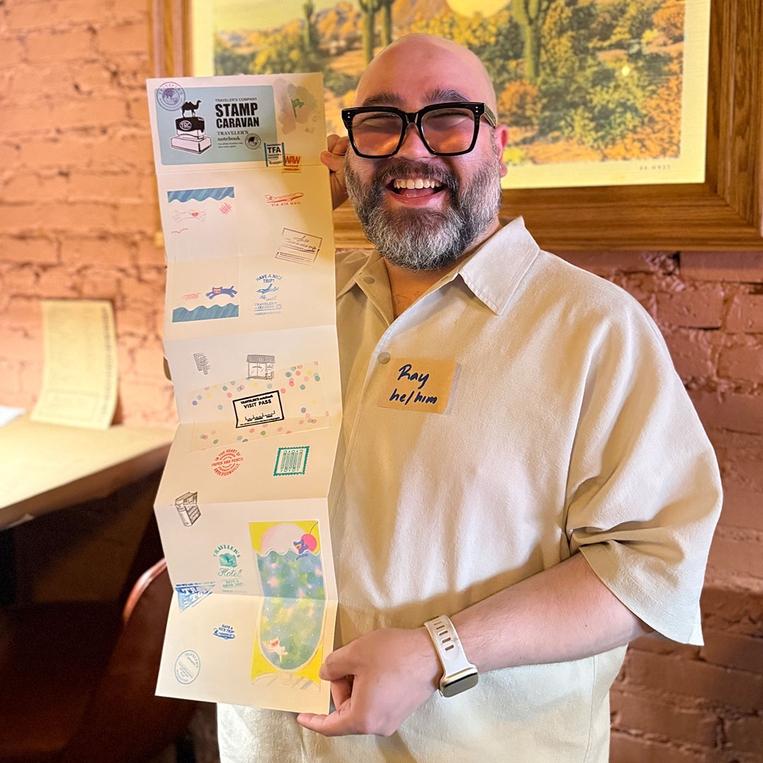 A TRAVELER'S notebook fan showing off their Accordion Refill with stamps collected from the event.