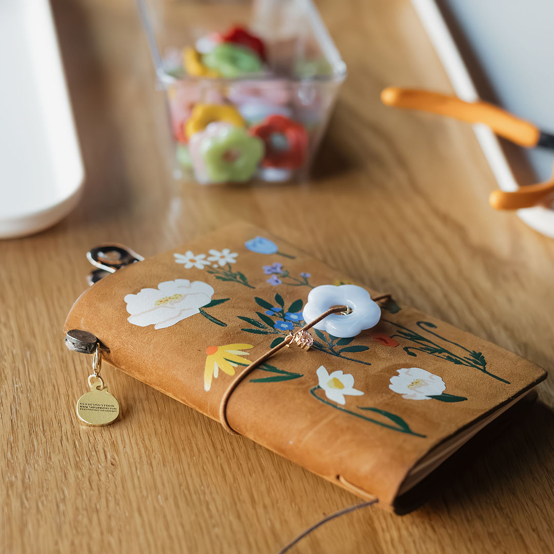 A customized TRAVELER'S notebook with press ons and charms.