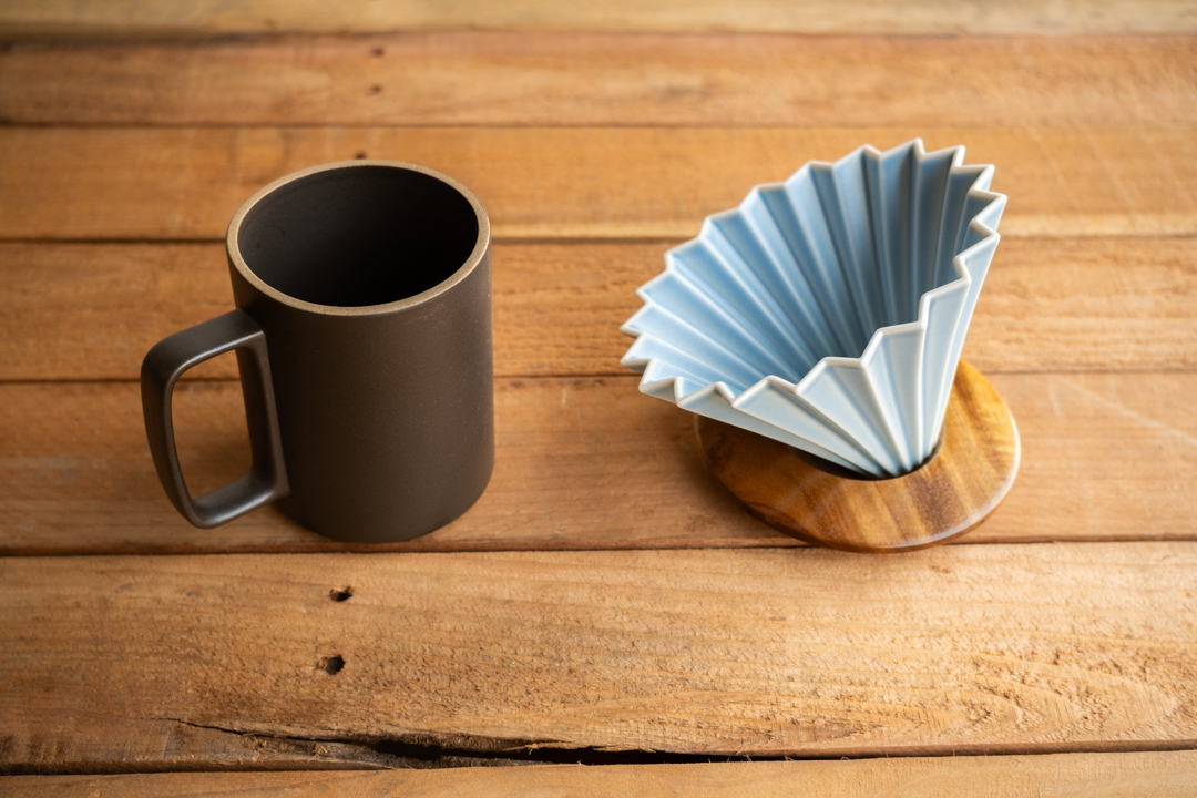 A black HASAMI mug and a blue ORIGAMI dripper with wood holder.