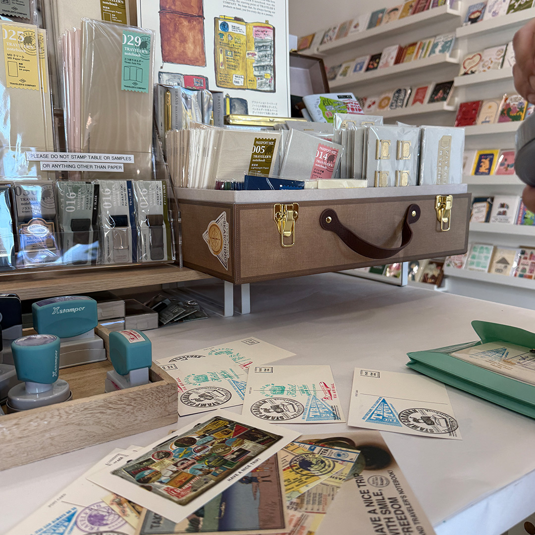 A tool box holds an array of TRAVELER'S COMPANY products next to the stamp station.
