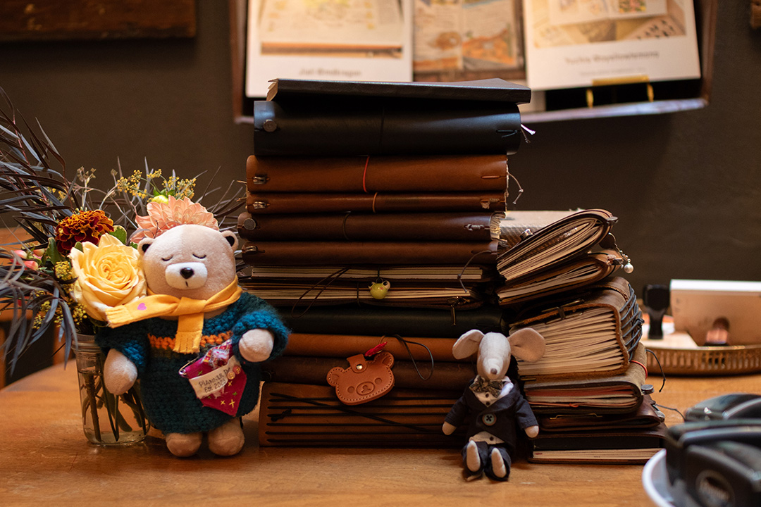 A display of many TRAVELER'S notebooks stacked on top of each other.