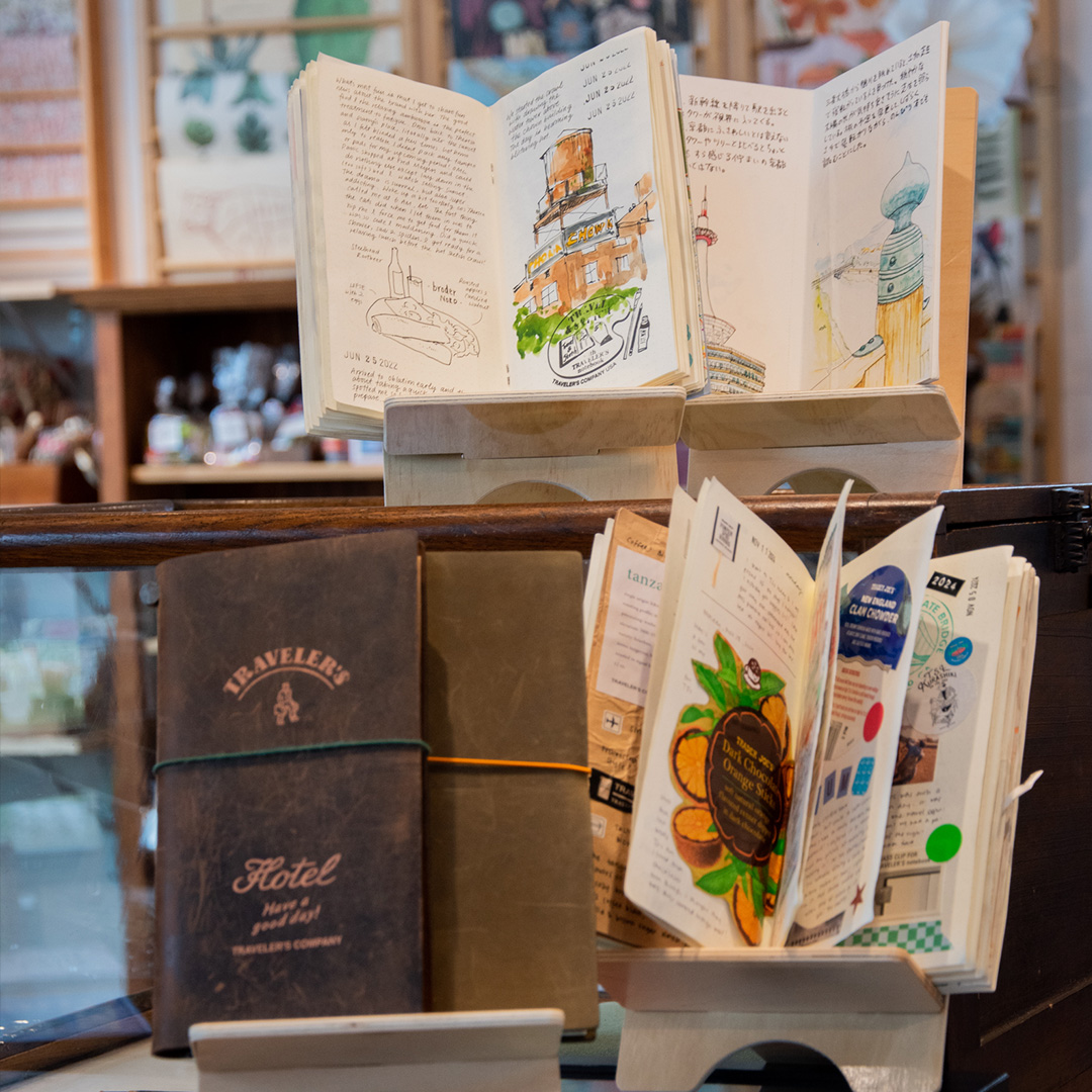 Various TRAVELER'S notebook and refills are displayed on the shelf.