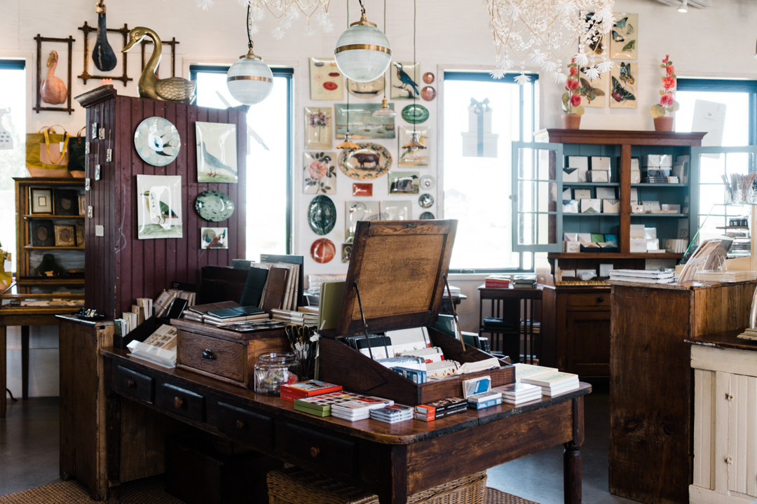 The interior of Paper and Grace stationery shop is filled with paper goods, stationery, and beautiful vintage wooden decor, and dried flowers.