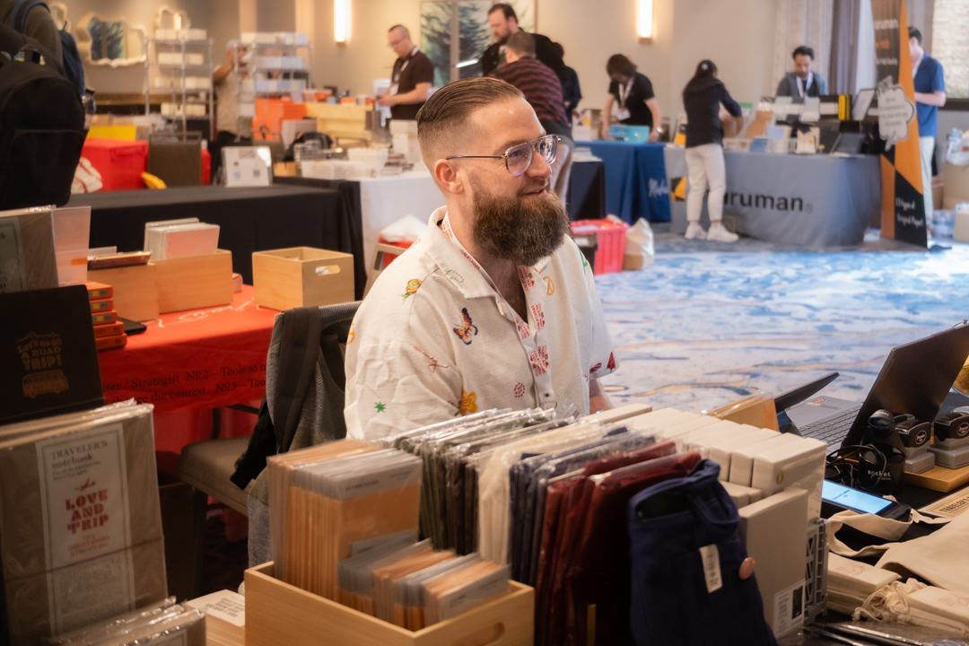 ATRC USA team member ringing up a customer's purchase at the TRAVELER'S COMPANY USA table at the California pen show.
