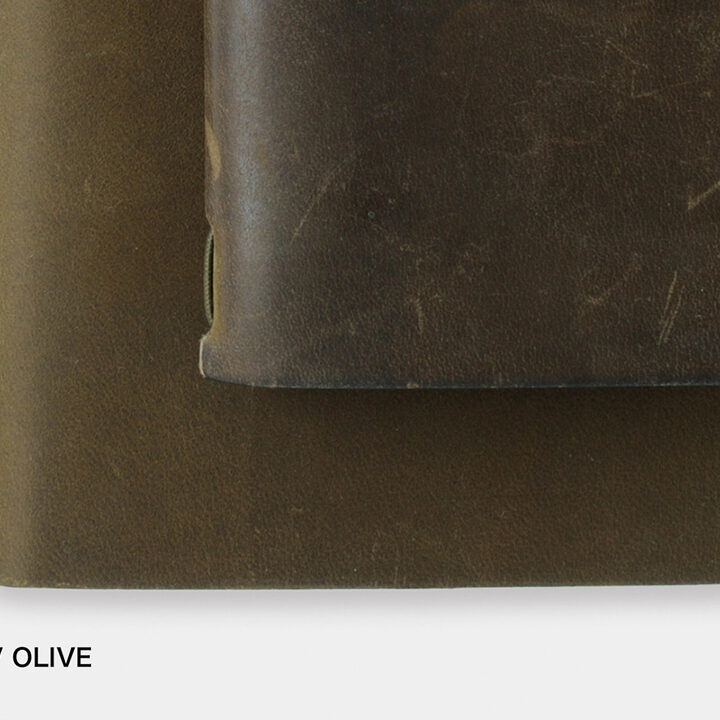 A close-up of a new Olive TRAVELER'S notebook beside a used Olive TRAVELER'S notebook to showcase the patina and aging process of leather with use and time.