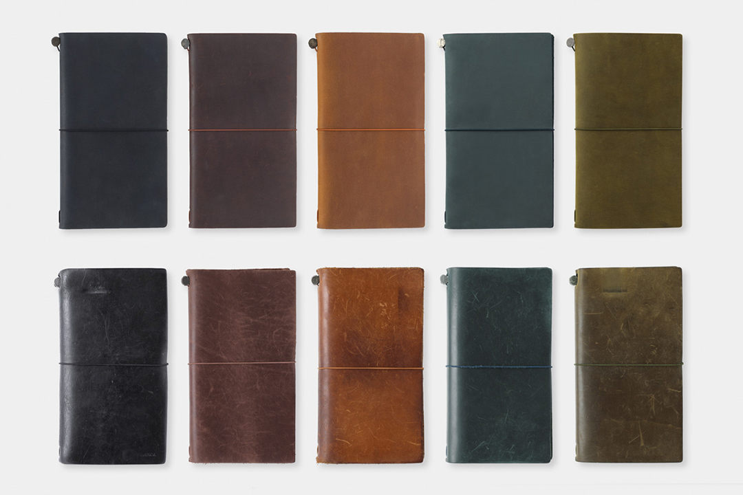 New Black, brown, camel, blue, and olive TRAVELER'S notebook above well used TRAVELER'S notebooks in the same colors, showcasing the patina and aging process of TRAVELER'S notebooks over time. 