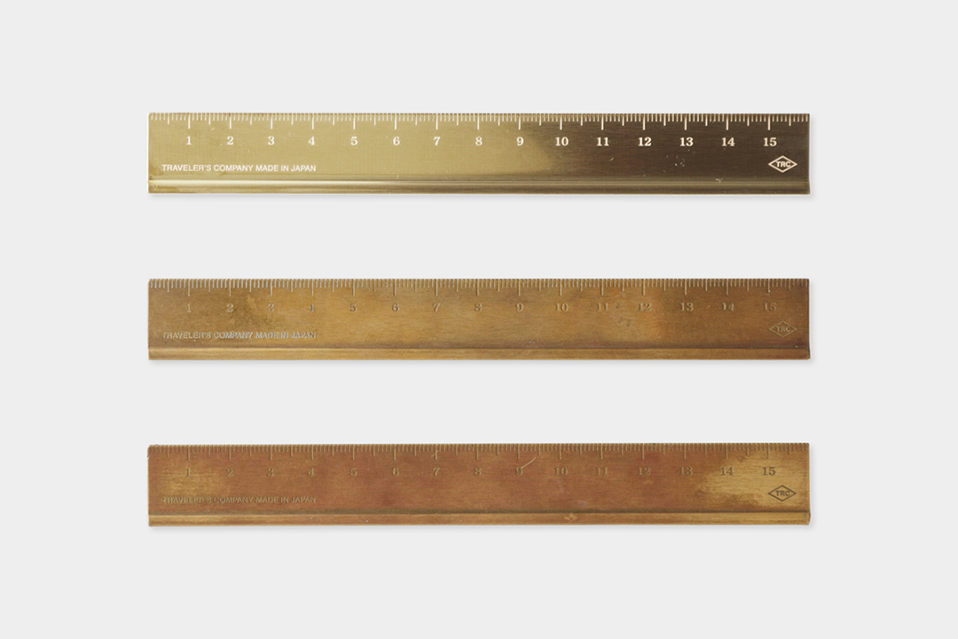 A new brass ruler beside a used brass ruler to showcase the patina and aging process of raw solid brass.