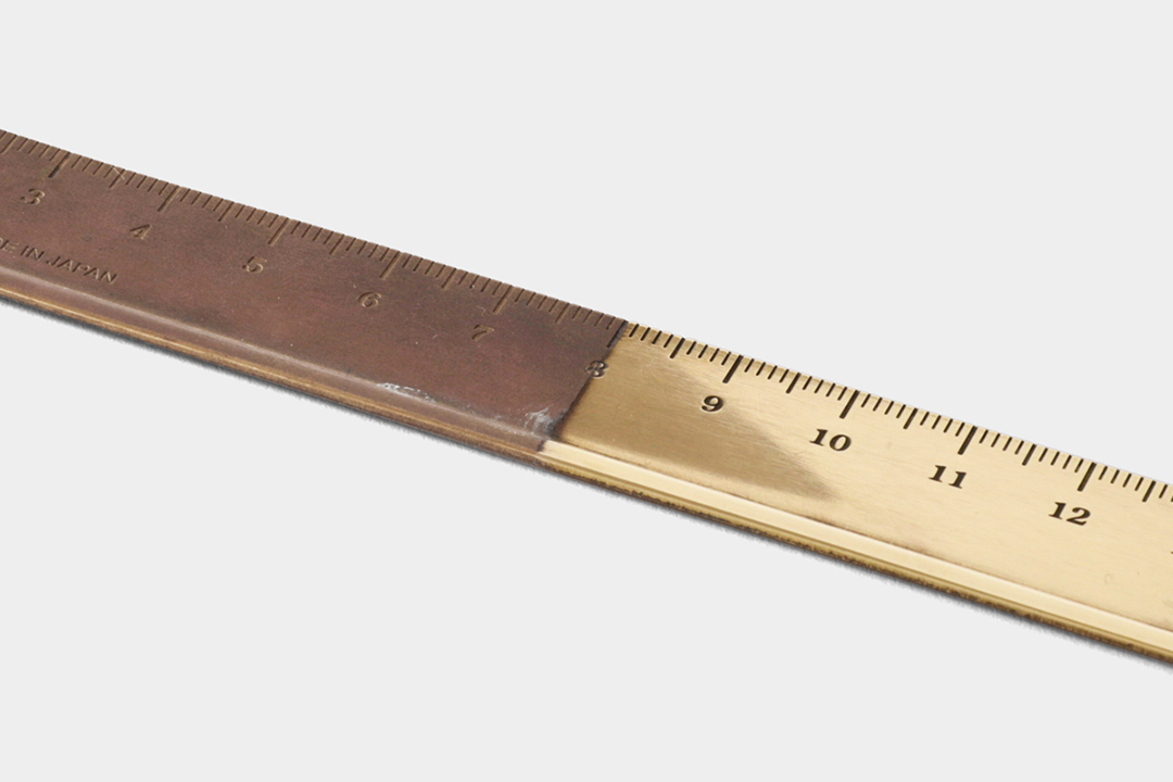A brass ruler that has been partially polished to contrast the patina and aging process of brass compared newly polished brass.