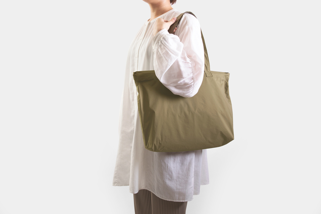 TF TO&FRO Rain Bag Olive modeled by a woman.