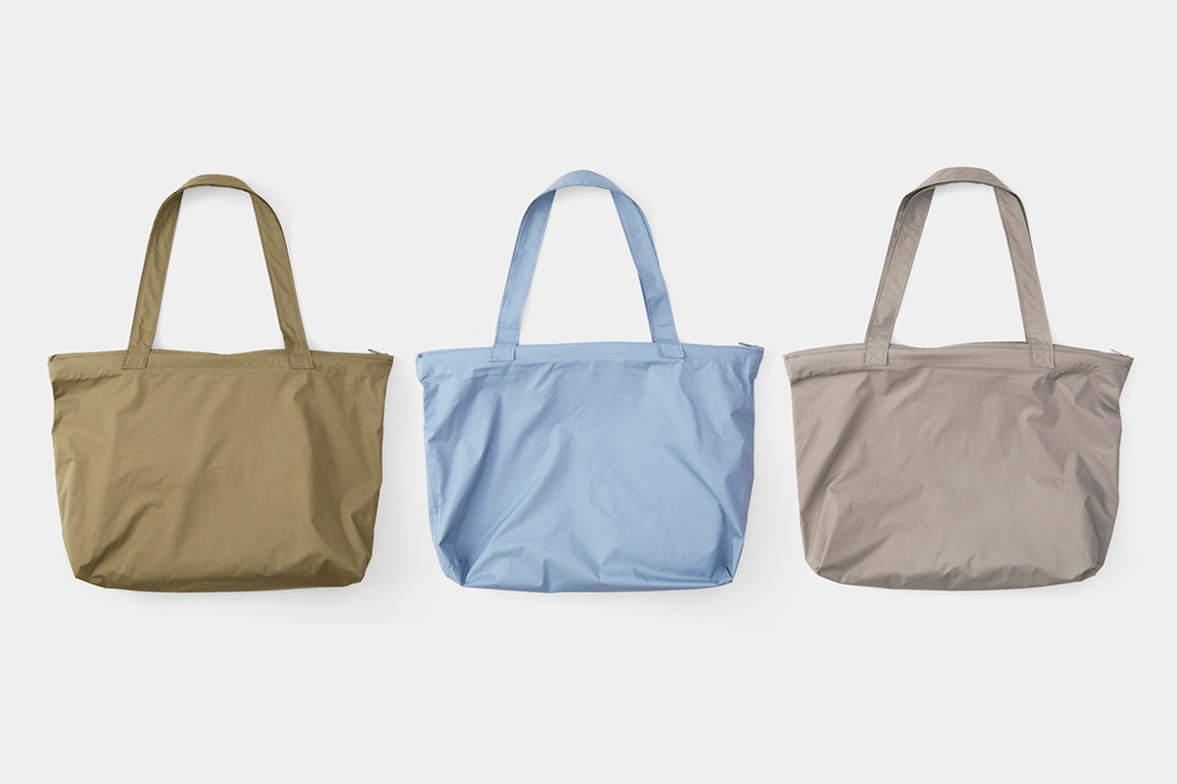 TRAVELER’S FACTORY TO&FRO Rain Bags in olive, blue gray, and warm gray.