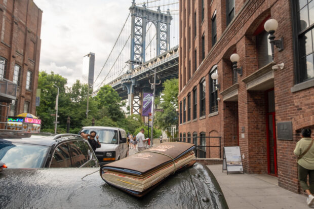 A view of the Manhattan Bridge from Dumbo, Brooklyn, with a TRAVELER'S notebook resting on a mailbox in the foreground.