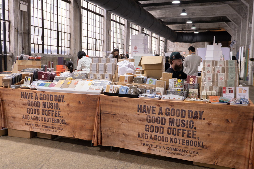 An angled view of the two TRC USA tables filled with TRAVELER'S notebook items at Stationery Fest 2026.
