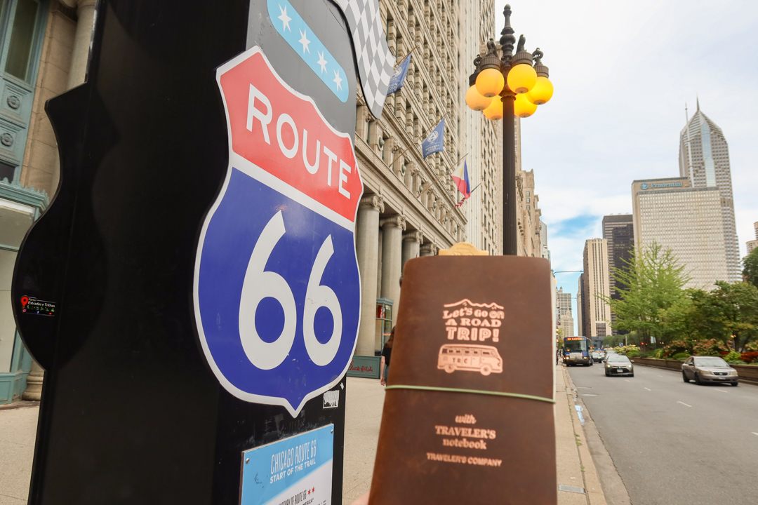 A TRAVELER'S notebook ROAD TRIP Edition next to the Route 66 sign.