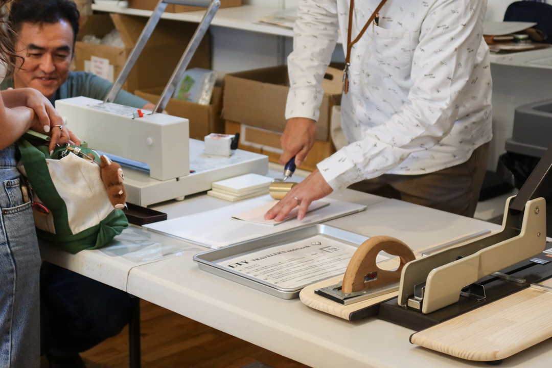 A craftsman help assemble refills with pages picked out by participants.