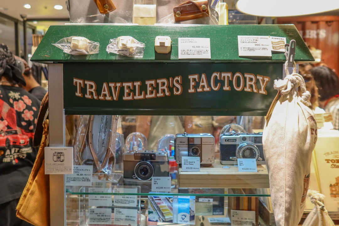 A vintage-style shadow box filled with TRAVELER'S notebook items and accessories.