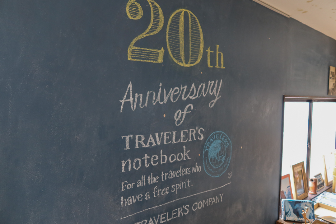 The chalkboard wall at TRAVELER'S FACTORY Nakameguro with a 20th Anniversary of TRAVELER'S notebook mural.