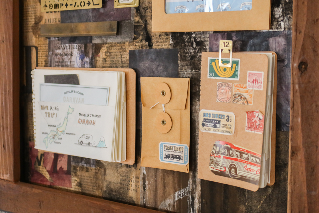 A vintage-style shadow box filled with TRAVELER'S notebook items and accessories.