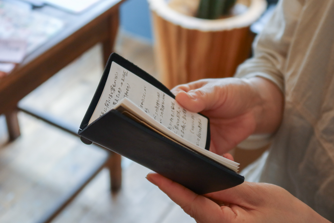 Someone holding a card size TRAVELER'S notebook in Black.