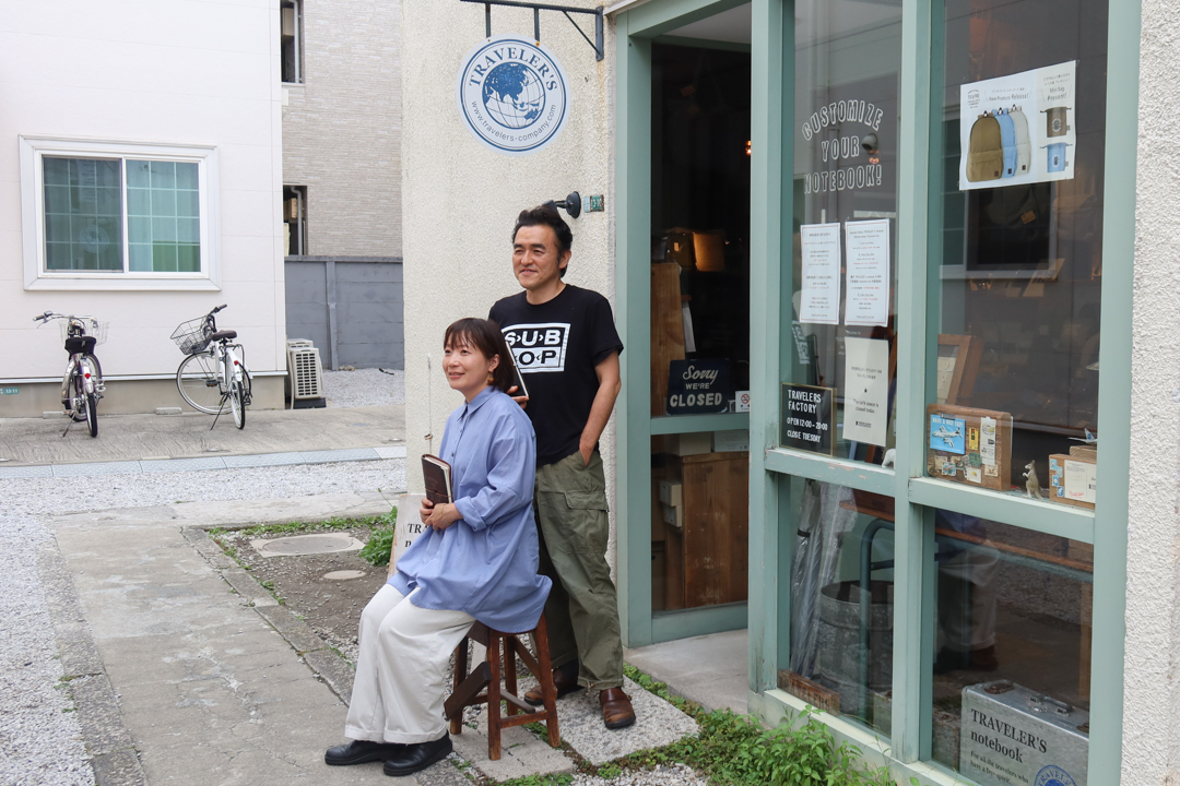 Miho and IIjima, the creators of TRAVELER'S notebook posing outside of TRAVELER'S FACTORY Nakamegeuro.