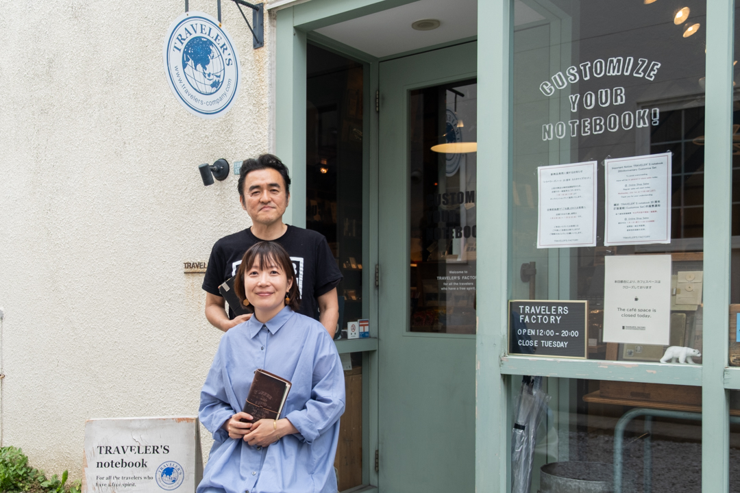 Miho and IIjima, the creators of TRAVELER'S notebook posing outside of TRAVELER'S FACTORY Nakamegeuro.